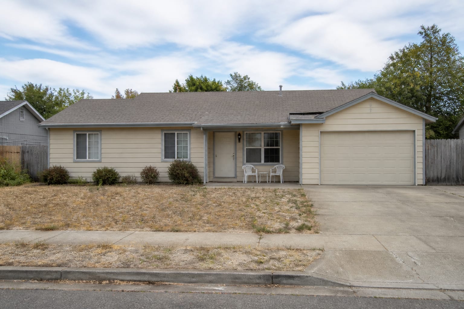 faded house exterior with washed out siding, weak trim contrast, small entry focus, bare foundation planting, and a roof color ignored by the palette.