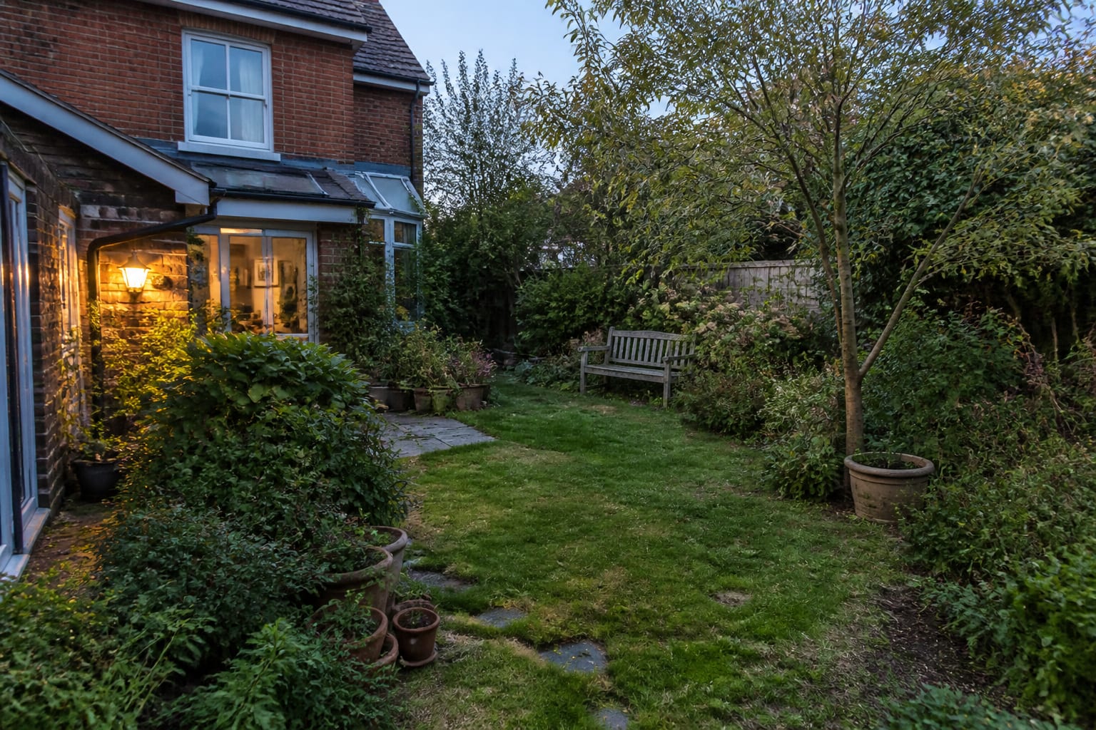 overgrown suburban garden with patchy lawn, narrow beds, scattered pots, and unclear seating potential ready for an AI redesign preview