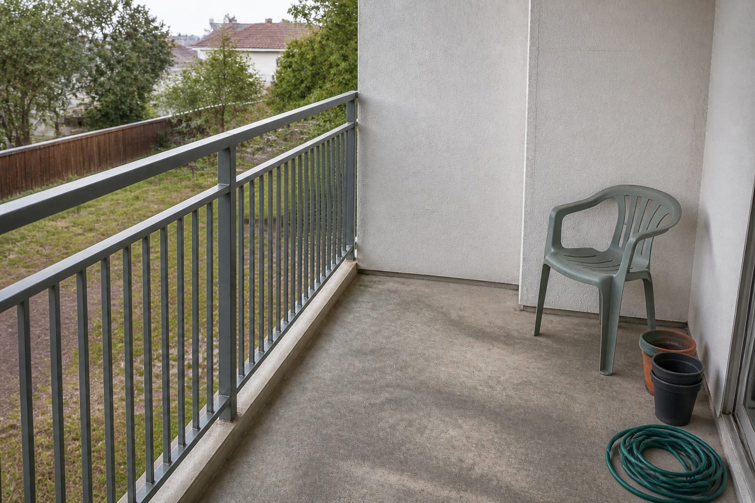 Empty bare apartment balcony with concrete floor and an empty railing before redesign
