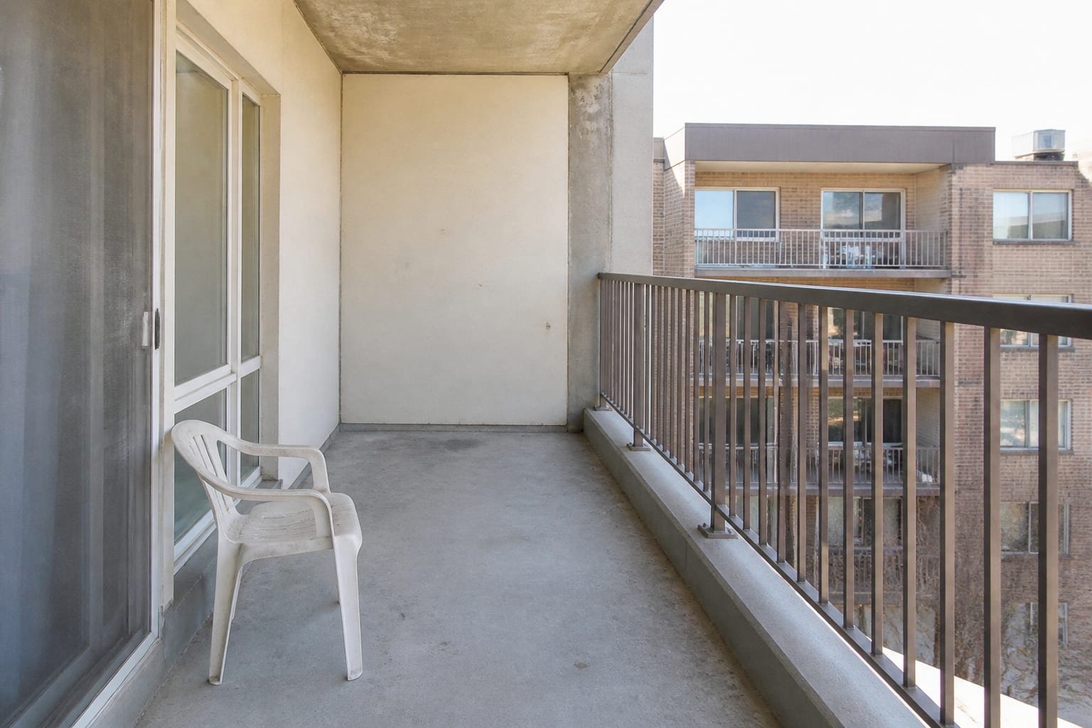 Empty bare apartment balcony with concrete floor and an empty railing before redesign