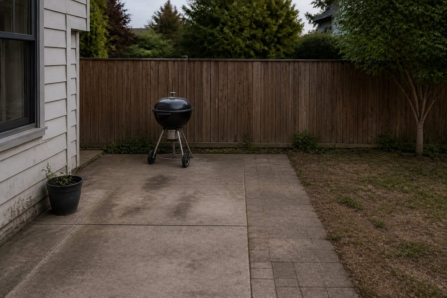 Plain concrete patio corner with a lone kettle grill and no counter or storage before redesign