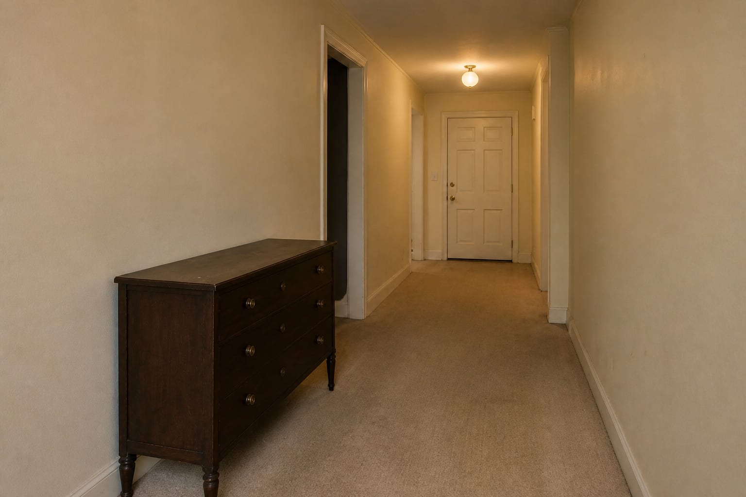 Crowded entry hallway with an antique mahogany chest, a second carved bench, mismatched art, two lamps, and a busy floral runner.