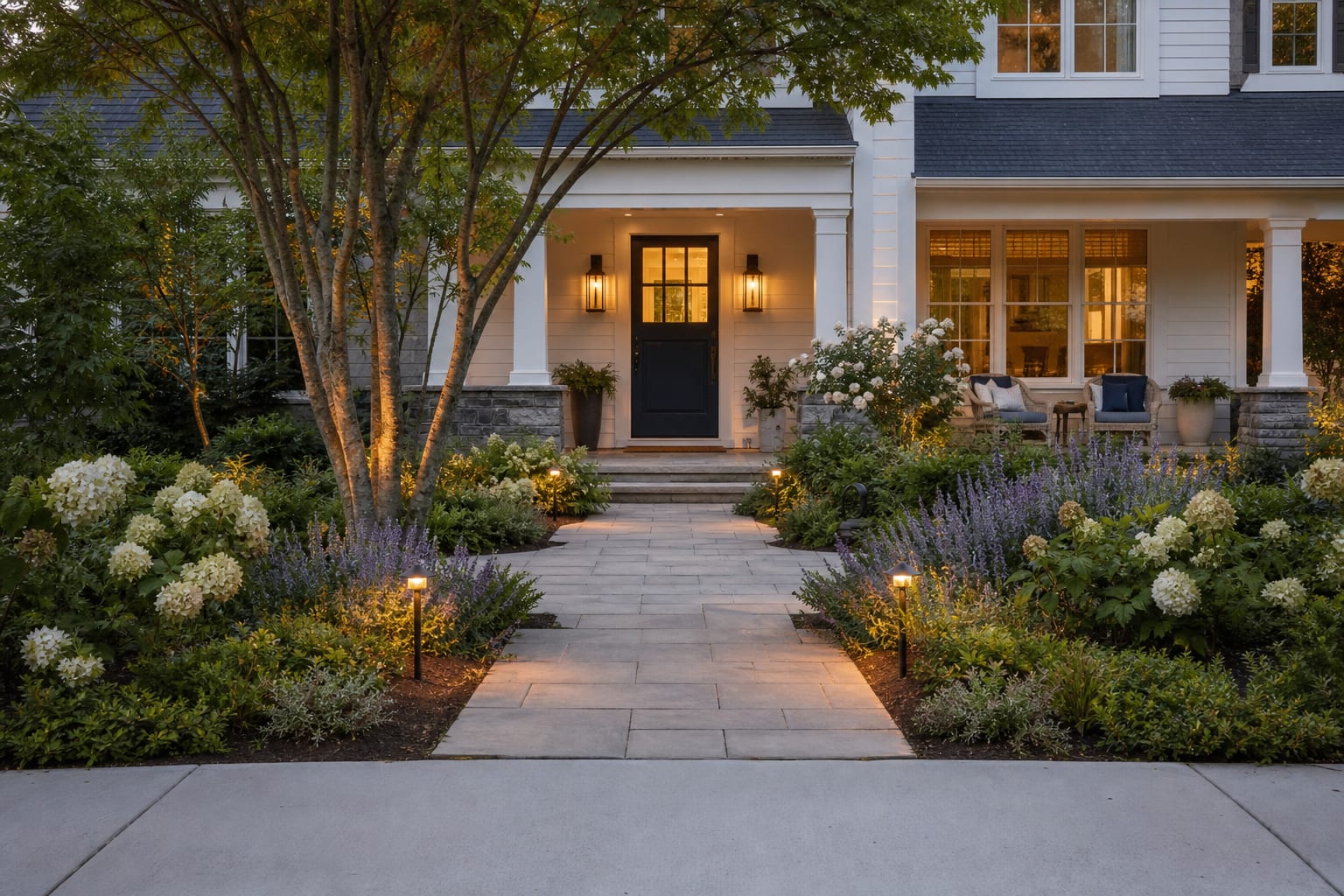 front walkway with stone pavers, layered planting, low path lights, and a clear view from sidewalk to painted front door