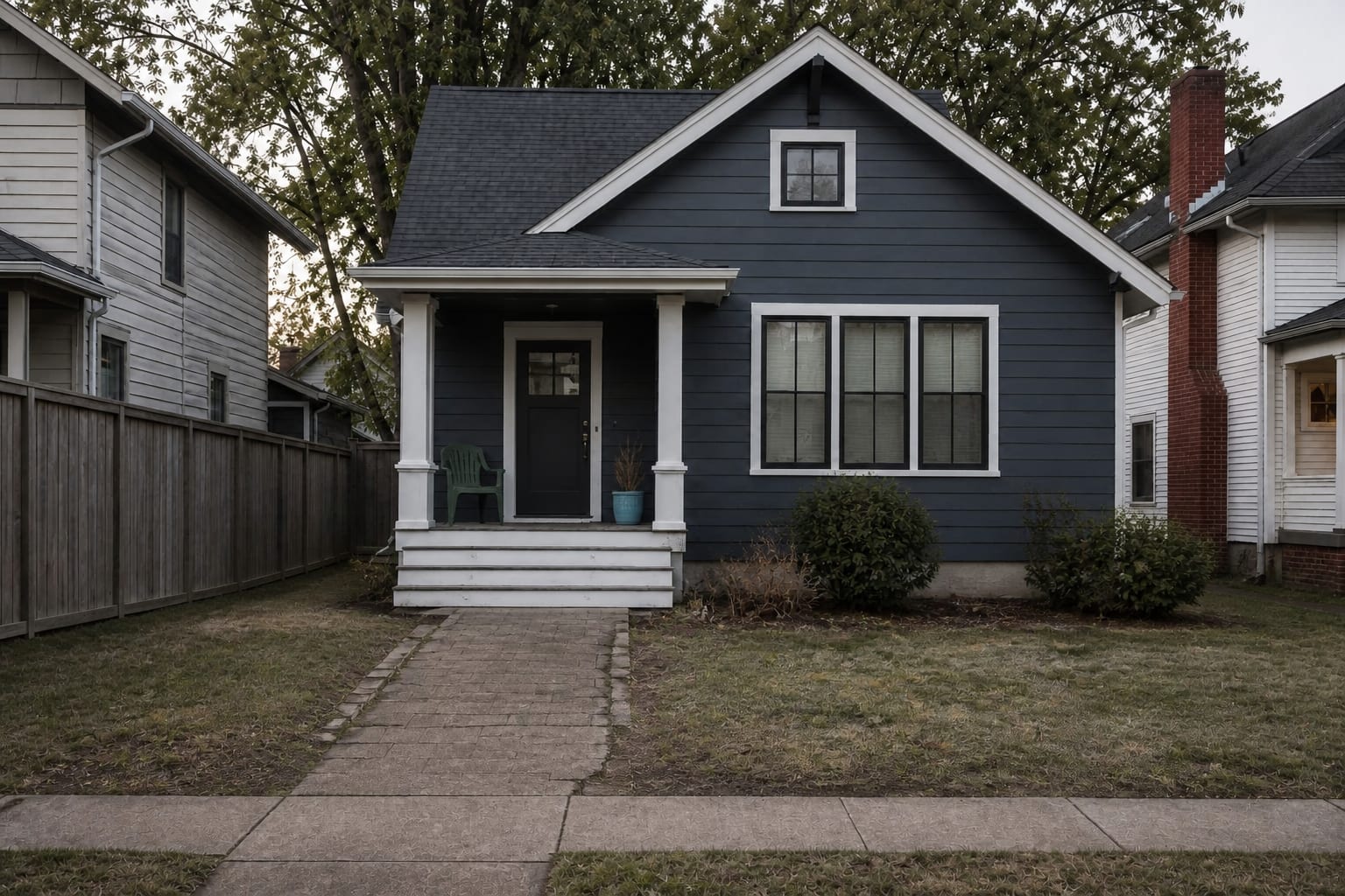 under designed front yard with thin lawn, narrow walkway, sparse shrubs, exposed foundation, and no lighting to guide visitors to the entry.