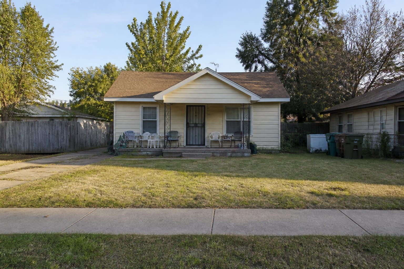 Open front yard fully exposed to the sidewalk with bare lawn and no screening before redesign