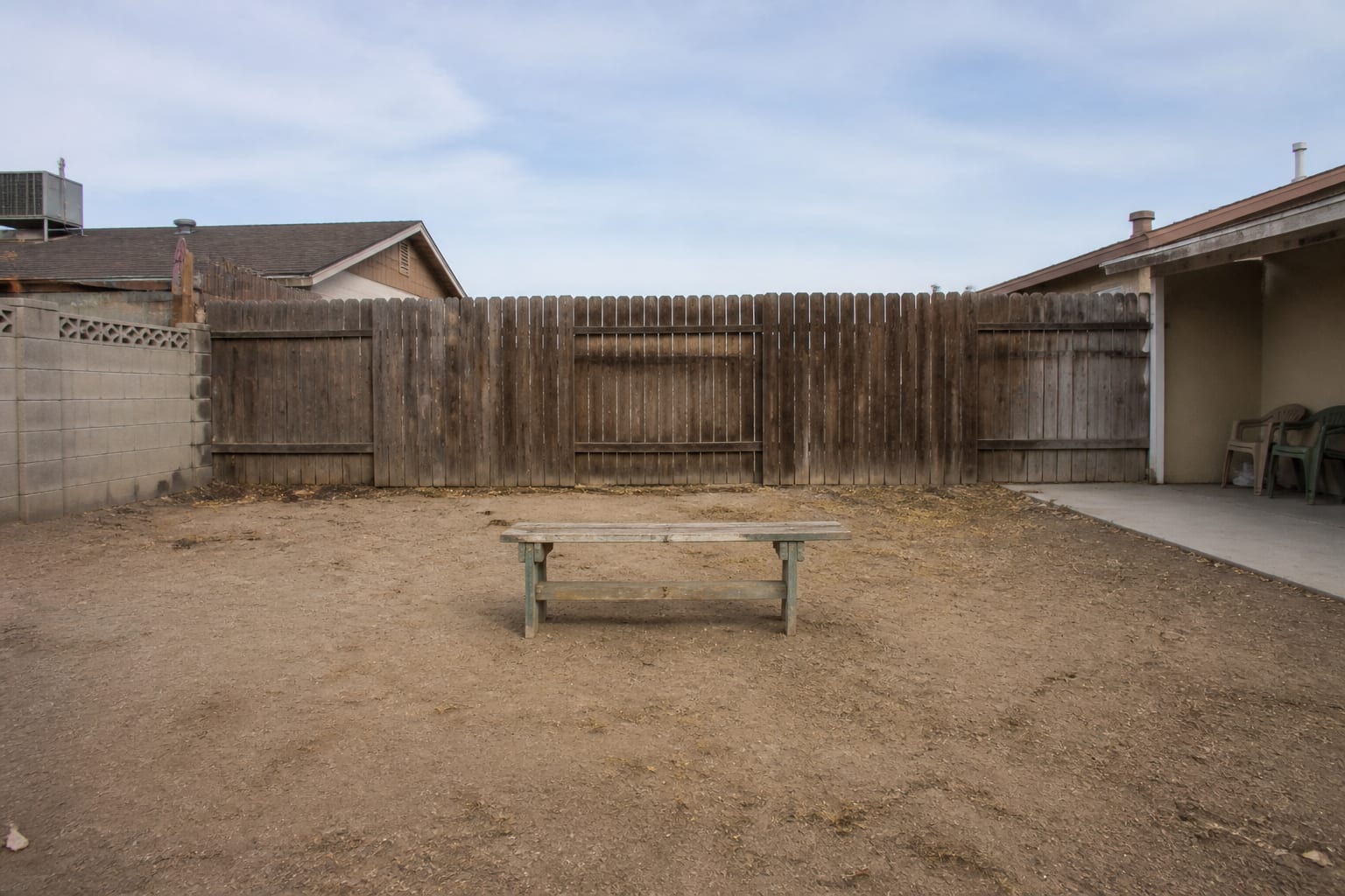 Plain bench stranded in the middle of an open lawn with no backdrop before redesign