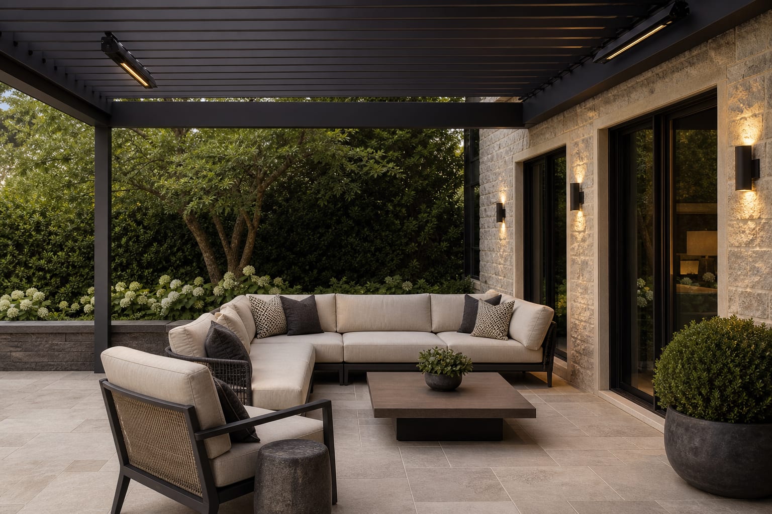 covered patio pergola with slim black infrared heaters, warm sconces, pale paving, and weatherproof lounge furniture