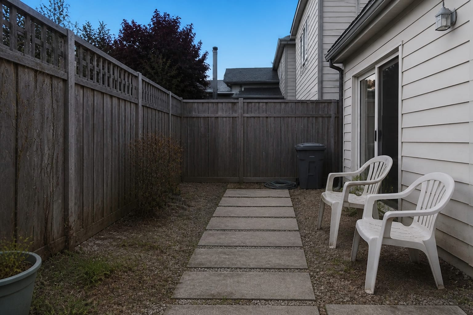 Cluttered suburban patio with bulky bright plastic furniture and scattered pots