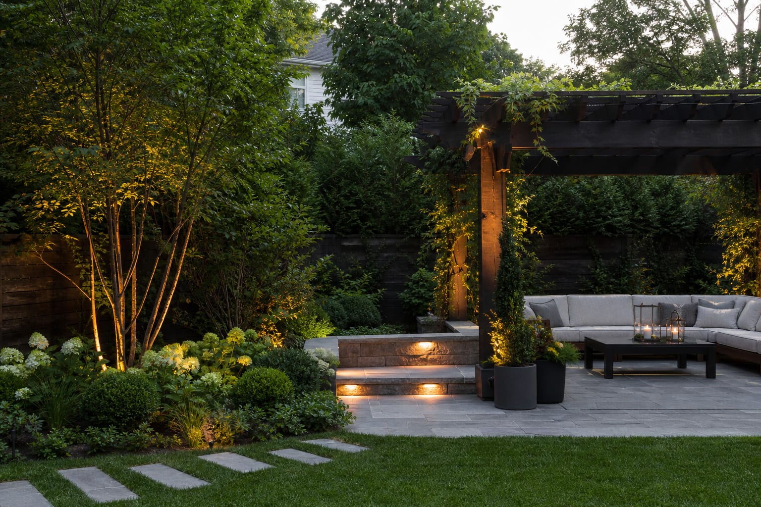 phone preview of a backyard garden showing selective warm uplights on trees, shrubs, and a pergola from the same camera angle