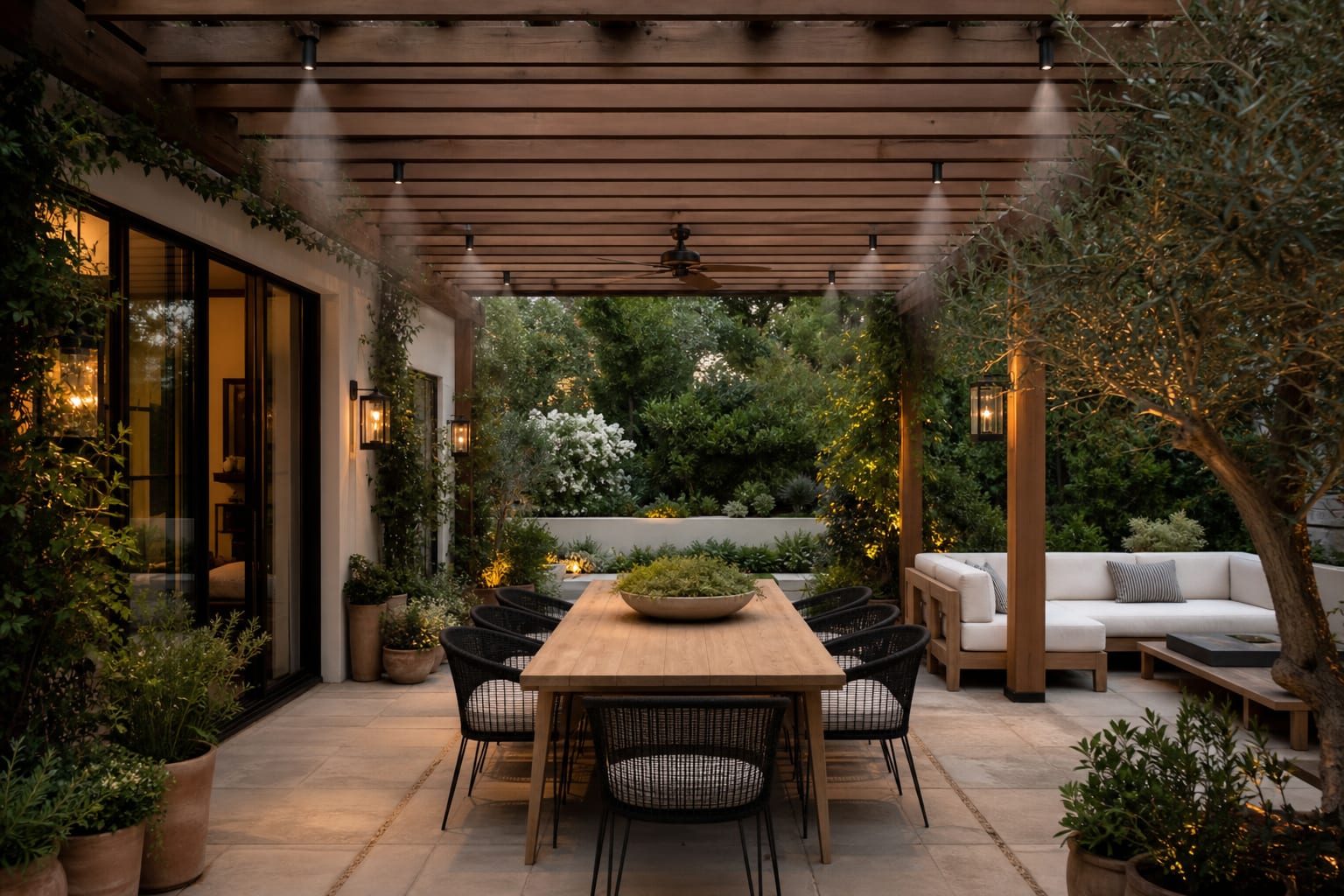pergola patio with discreet misting nozzles along the beam, washable cushions, potted herbs, and clear dining circulation
