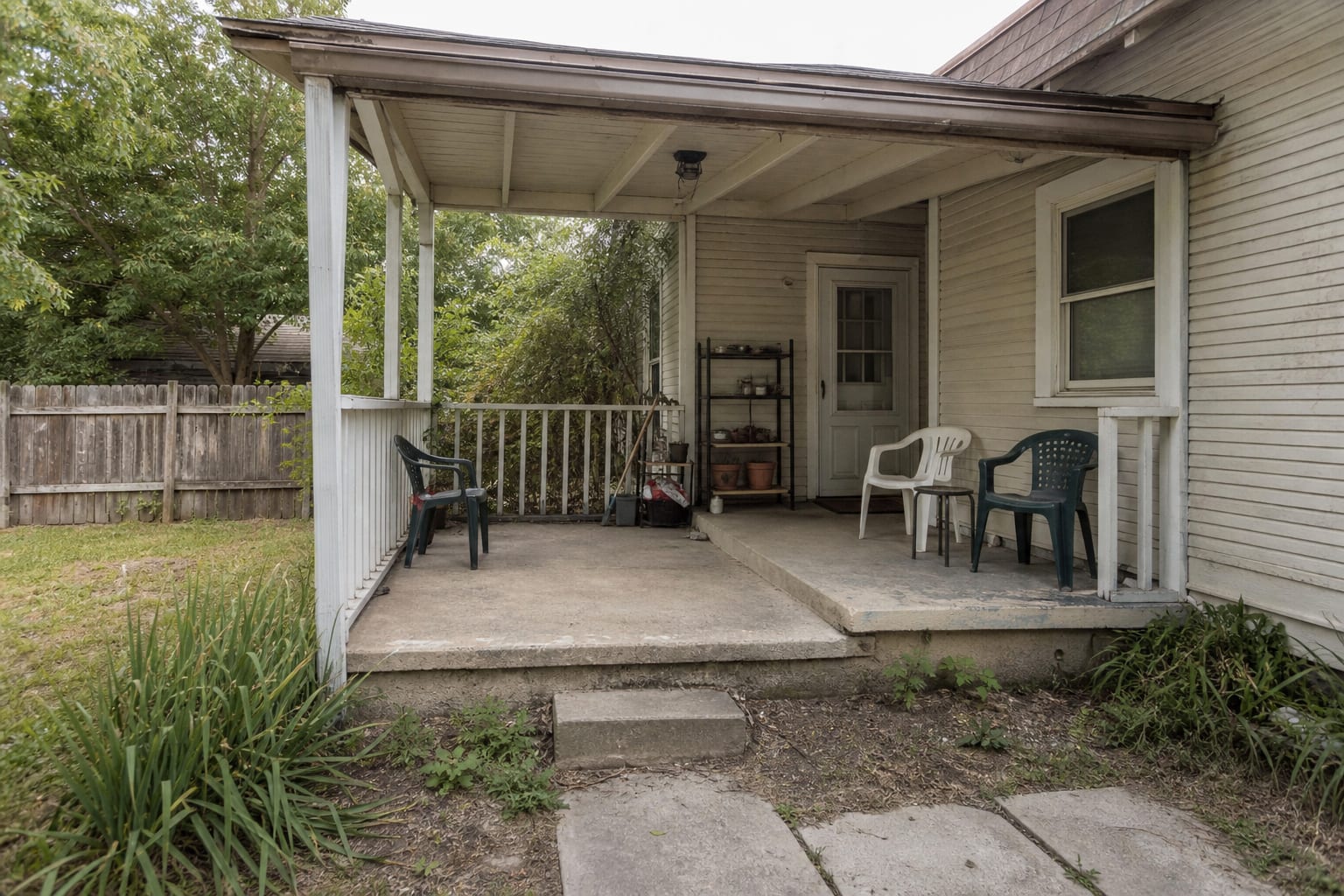 unfinished porch with open railings, scattered chairs, exposed bugs, small ceiling light, and no clear seating plan.